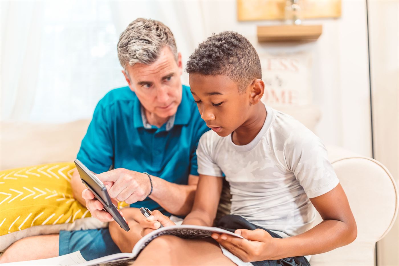 An adult and a child looking at a book together