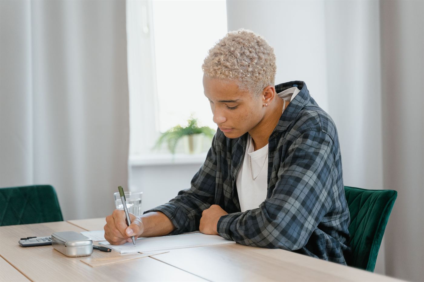 A teenager writing in a notebook