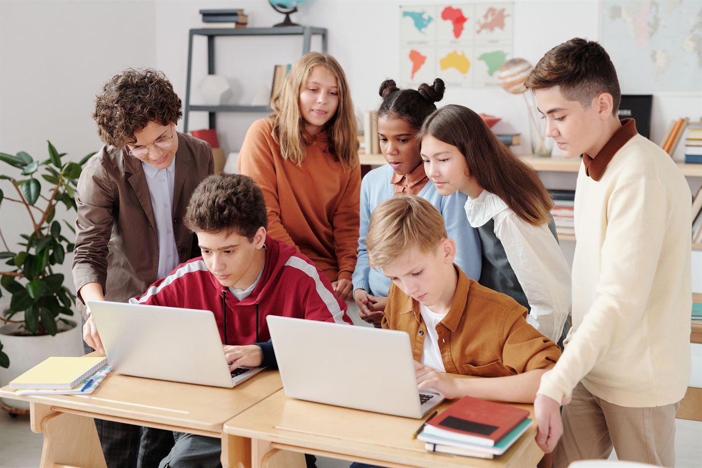 A teacher and students looking at a laptop